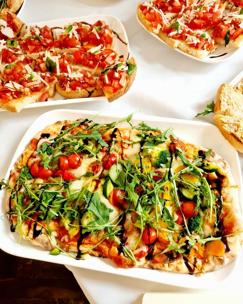 Pinsa mit Rucola, Tomaten und Balsamico, dazu Bruschetta